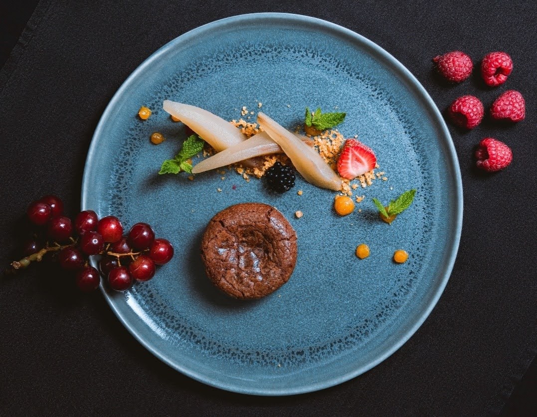 Plated chocolate fondant dessert with berries for bespoke dining events